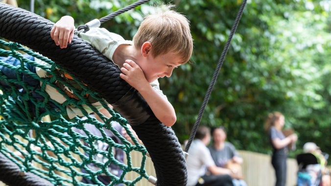 Children enjoy playing in the play area, Rook Wood at Penrhyn Castle, Gwynedd